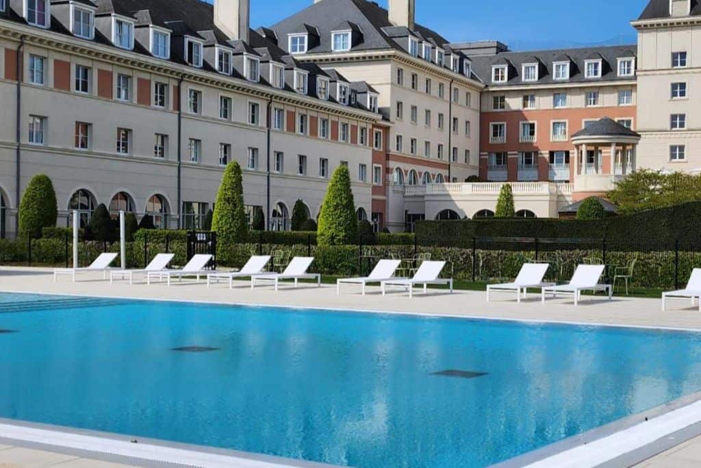 View of the outdoor pool in with the Dream Castle Hotel behind. One of the best family Hotels near Disneyland Paris